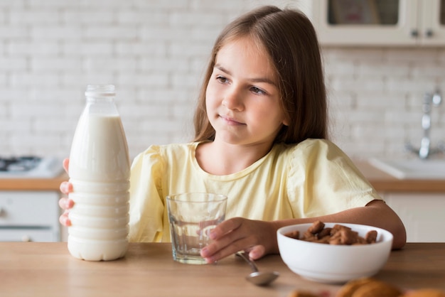 Medium shot girl holding milk bottle