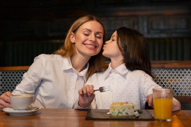 Medium shot girl kissing woman