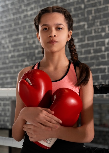 Medium shot girl learning boxing