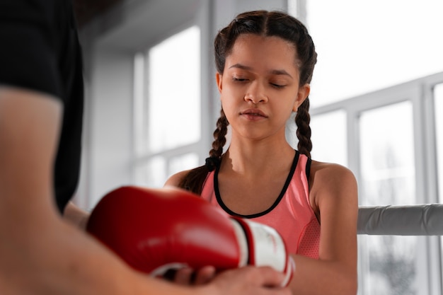 Medium shot girl learning boxing