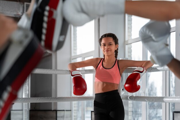 Medium shot girl learning boxing