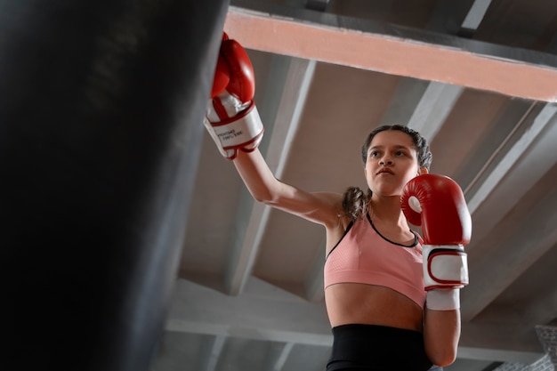 Medium shot girl learning boxing