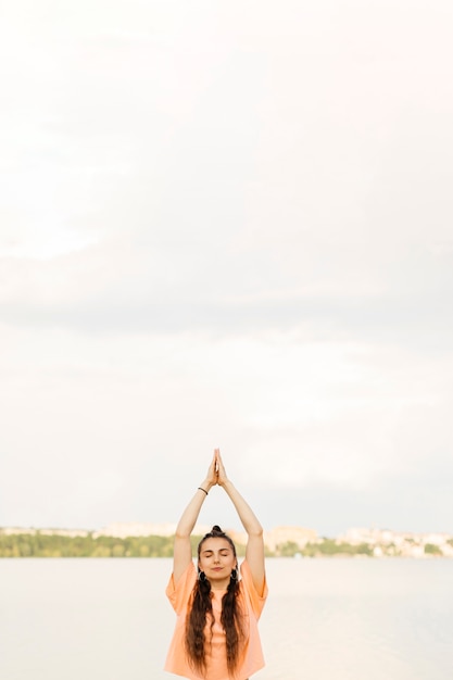 Free photo medium shot girl meditating outdoors