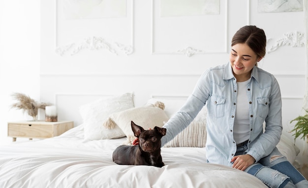 Free Photo medium shot girl petting dog in bed