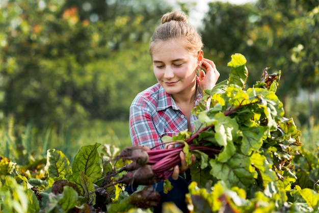 Medium shot girl picking up vegetables