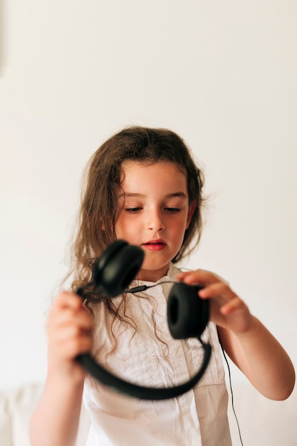 Medium shot girl putting on headphones