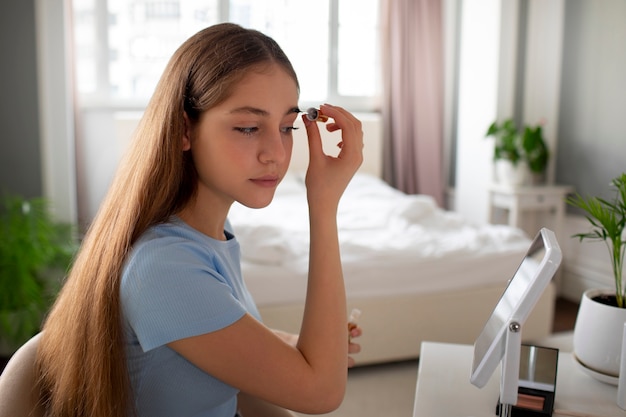 Free photo medium shot girl putting on makeup