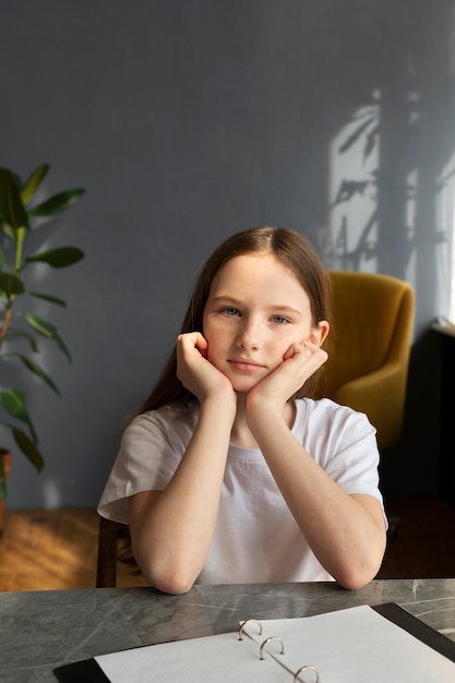 Free photo medium shot girl sitting at desk