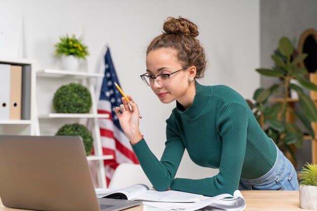 Medium shot girl studying with laptop