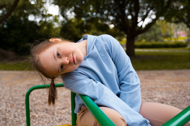 Medium shot girl with down syndrome in park