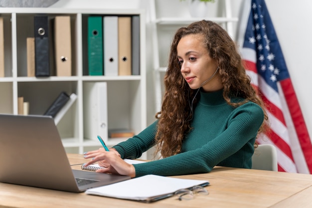 Medium shot girl with headphones and laptop indoors