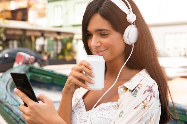 Medium shot girl with phone and headphones