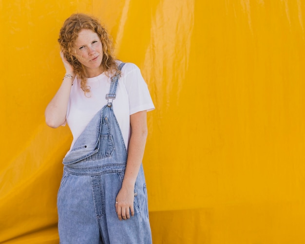 Free photo medium shot girl with yellow background and copy-space