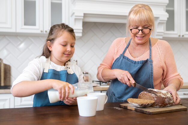 Medium shot girl and woman cooking