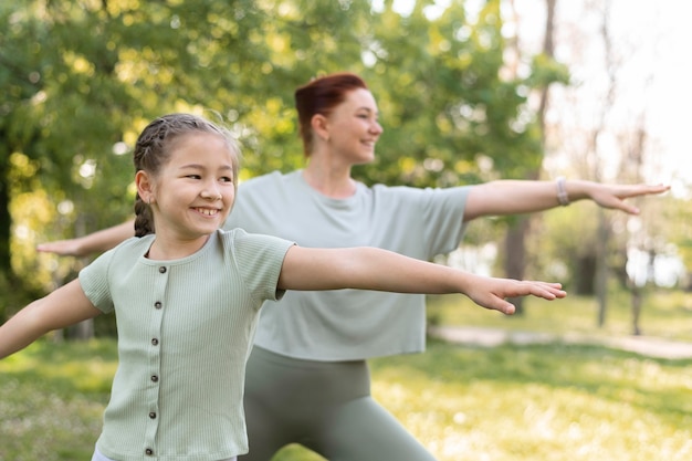 Medium shot girl and woman exercising