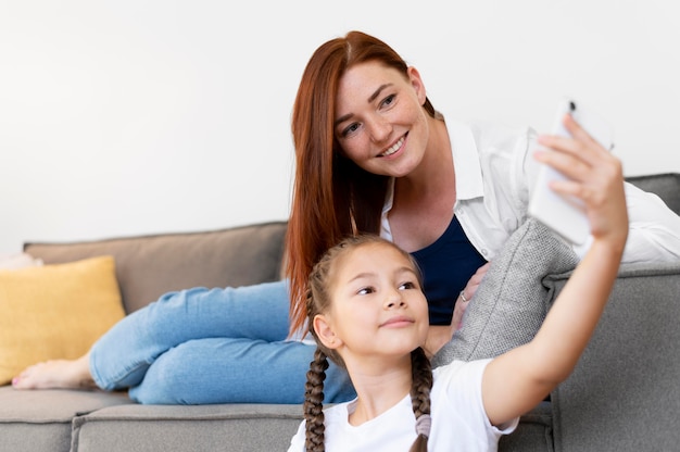 Free photo medium shot girl and woman taking selfie