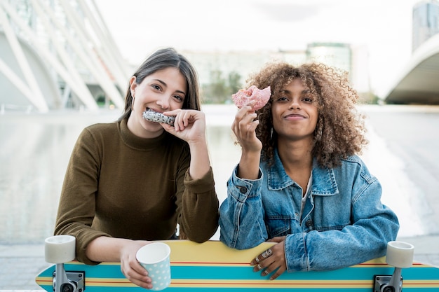 Medium shot girls eating doughnuts