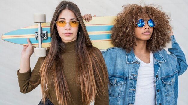 Medium shot girls holding skateboard