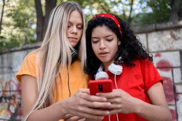 Free Photo medium shot girls looking at phone