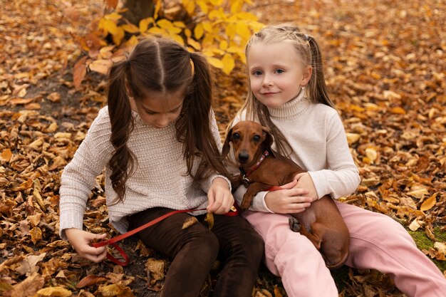 Free Photo medium shot girls with dog in nature