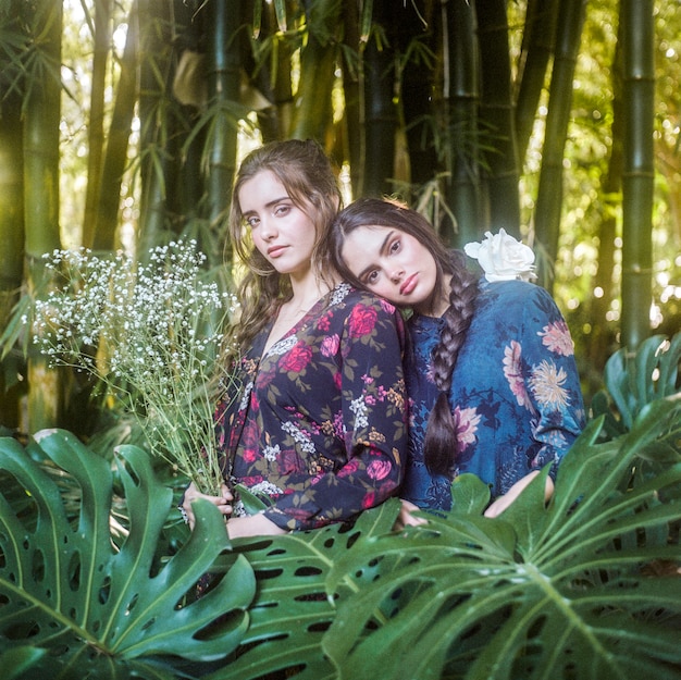 Free photo medium shot of girls with monstera leaves