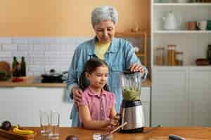 Free photo medium shot grandma and girl cooking together