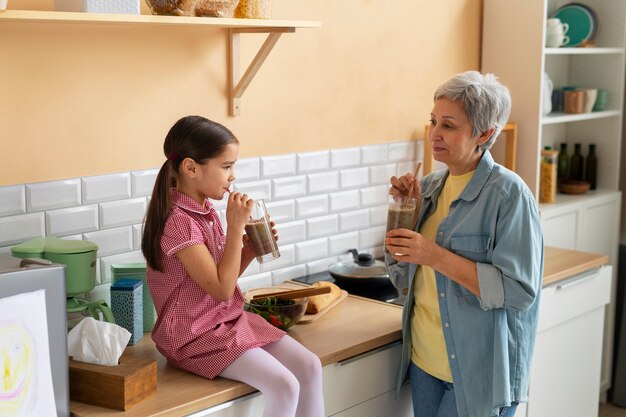 Medium shot grandma and girl cooking together