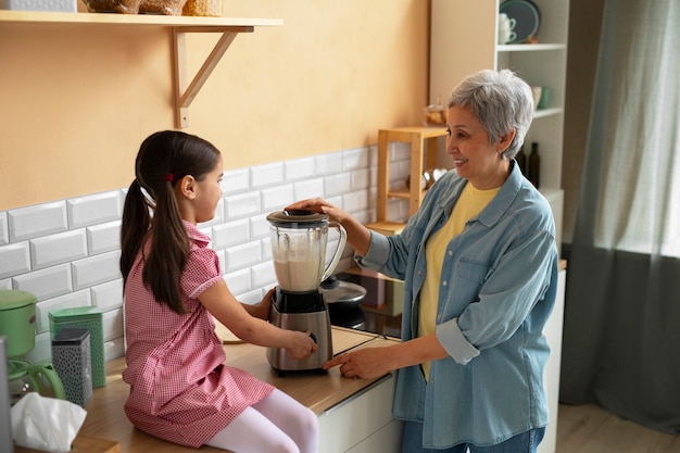 Medium shot grandma and girl cooking together