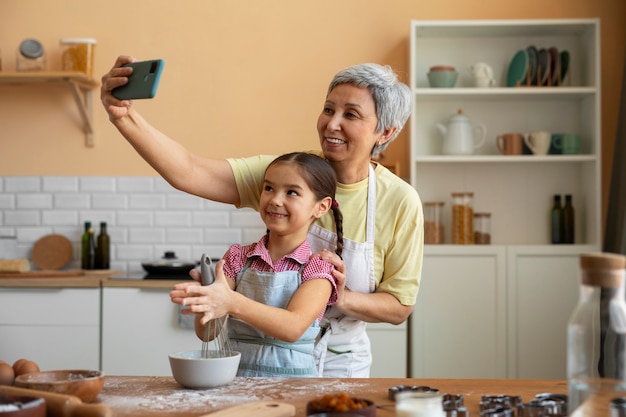 Free photo medium shot grandma and girl cooking together