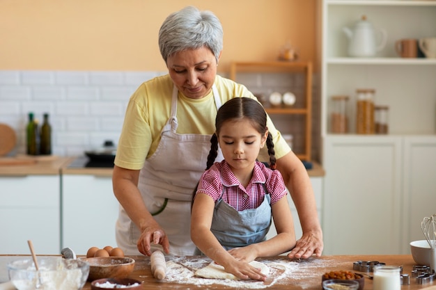 Medium shot grandma and girl cooking together