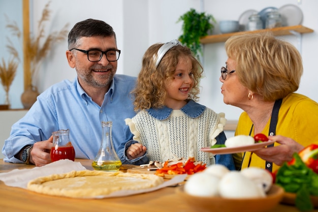 Free photo medium shot grandparents and girl in kitchen