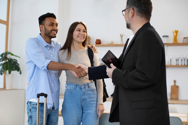 Free photo medium shot guest and host shaking hands