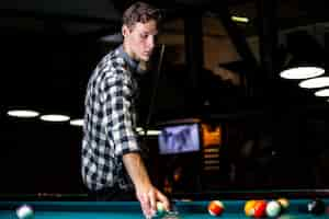 Free photo medium shot guy holding white pool ball