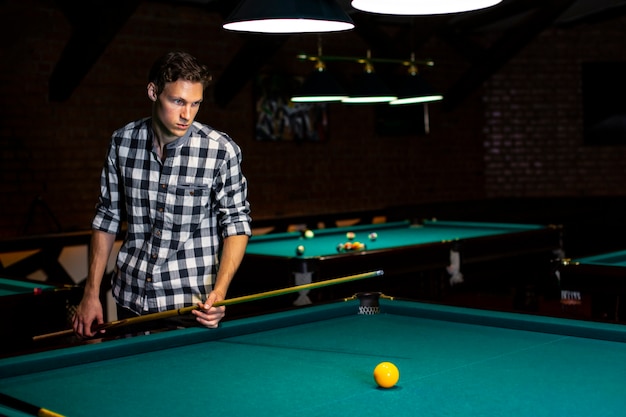 Medium shot guy looking at yellow pool ball