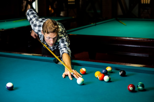 Free Photo medium shot guy with pool cue and billiard table 