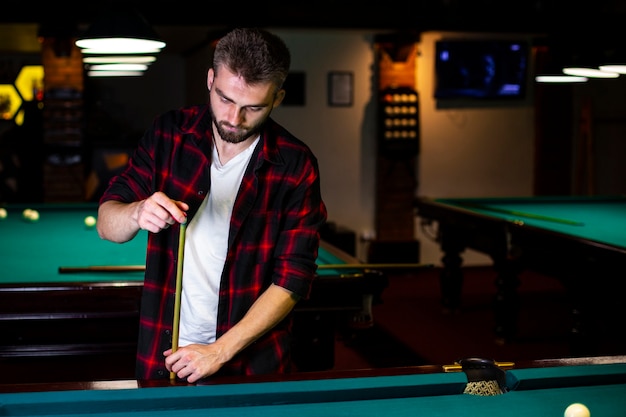 Free photo medium shot guy with pool cue and chalk