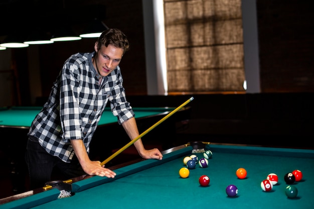 Free photo medium shot guy with pool cue looking away