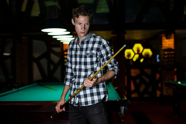 Free photo medium shot guy with pool cue stick