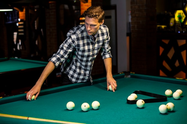 Free photo medium shot guy with white balls and triangle