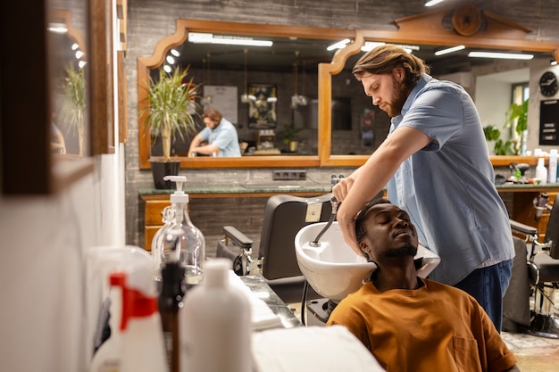 Medium shot hairdresser washing man's hair