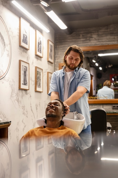 Medium shot hairdresser washing man's hair