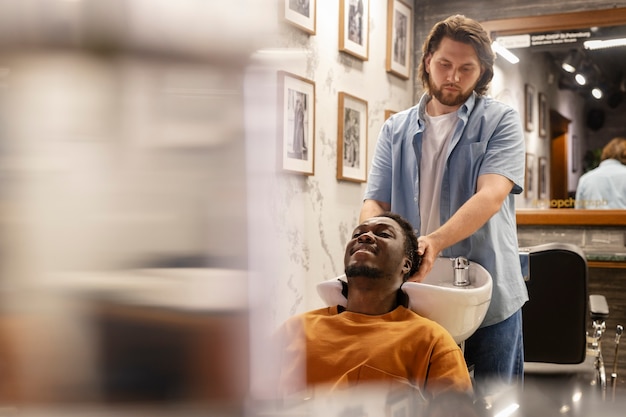 Medium shot hairdresser washing man's hair