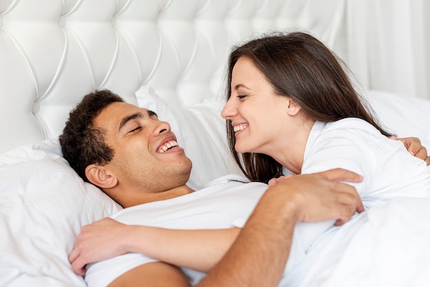 Medium shot happy couple in bed together