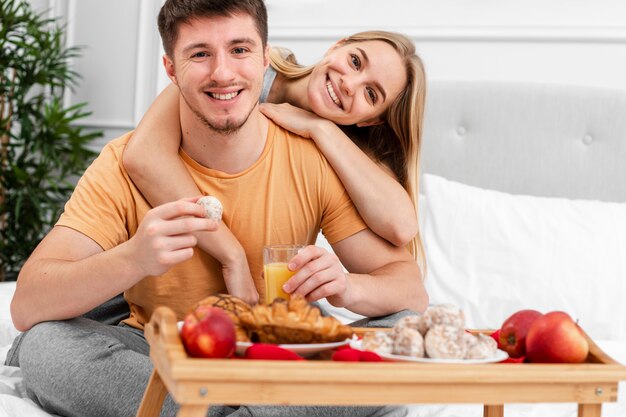 Medium shot happy couple with breakfast in bed