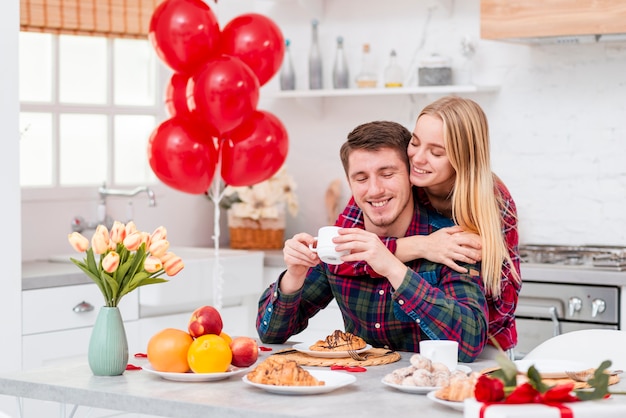 Medium shot happy couple with breakfast in the kitchen