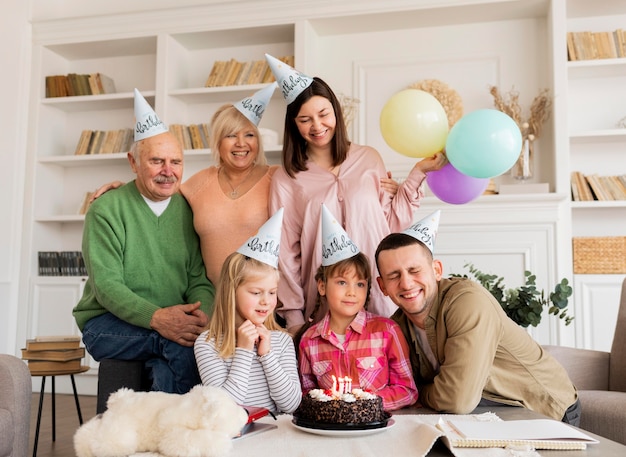 Free photo medium shot happy family posing with cake