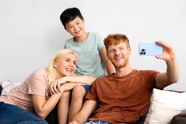 Medium shot happy family taking selfie