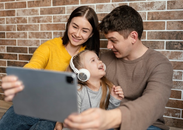 Medium shot happy family with tablet