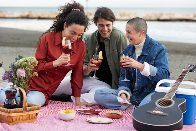 Free photo medium shot happy friends having picnic