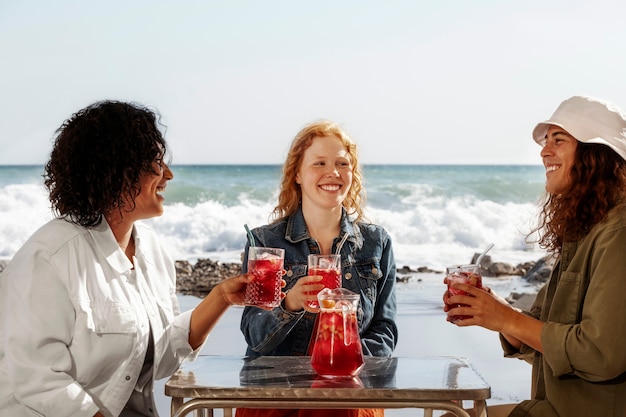 Medium shot happy friends at seaside